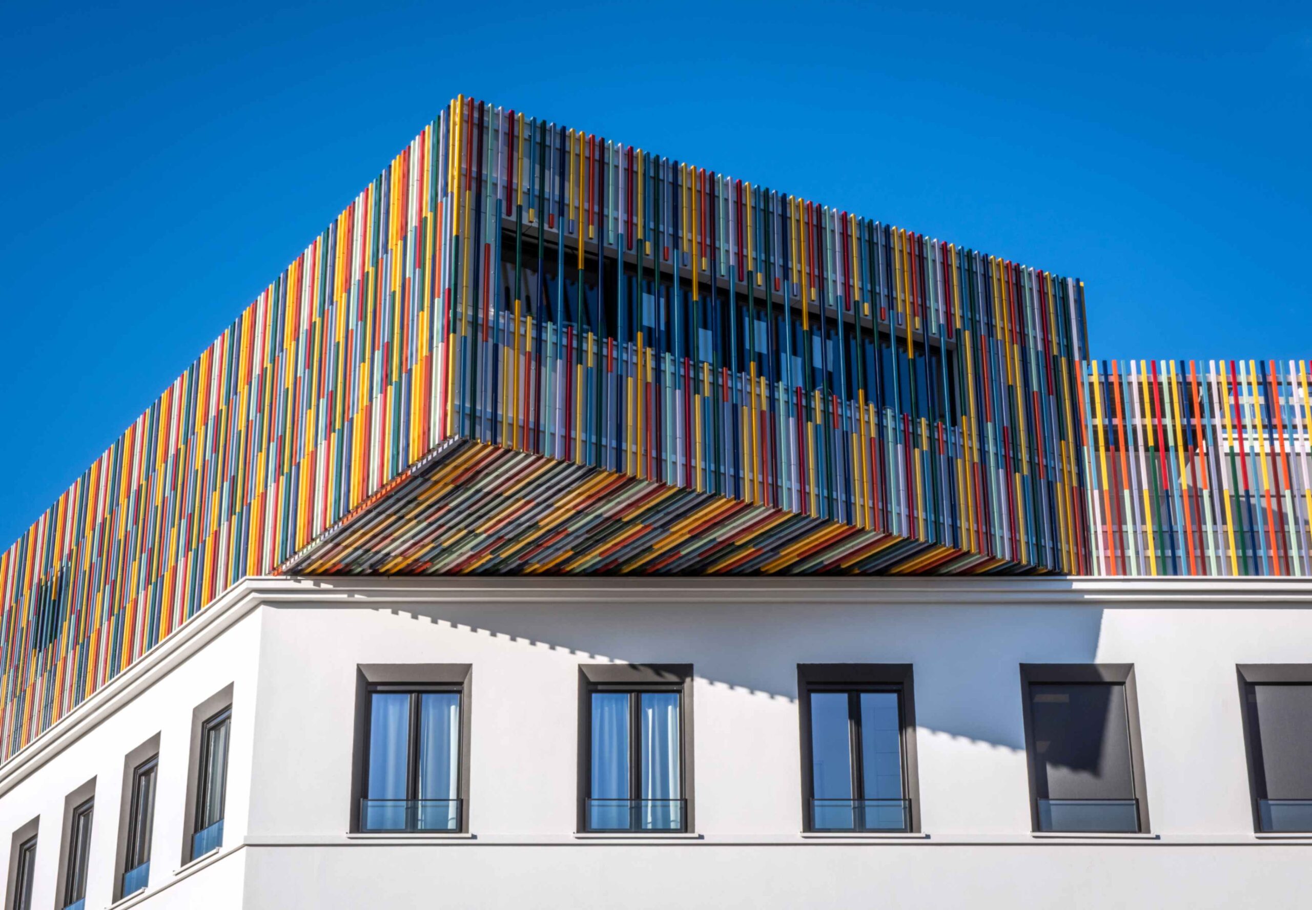 Gebouw met terracotta gekleurde baquettes op bovenste verdieping