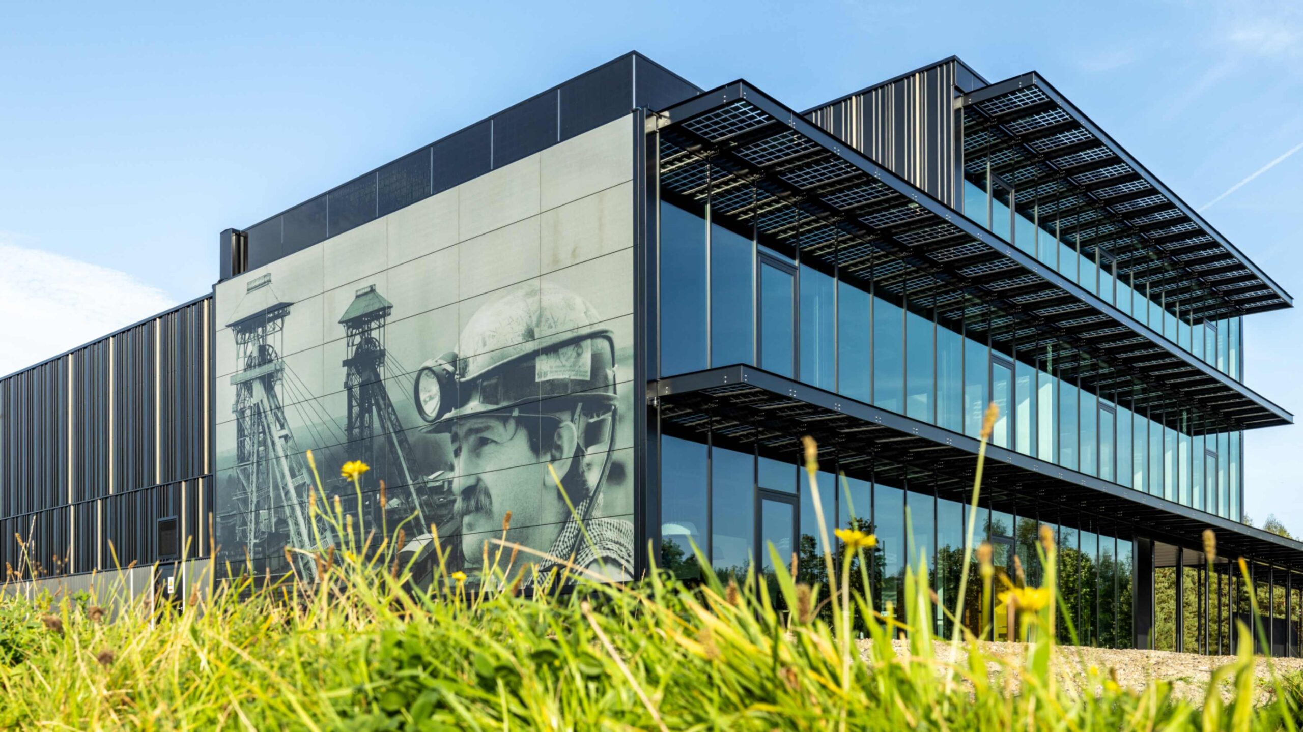 Nieuw HQ van Soltech in Genk, afbeelding van mijnwerker in BIPV panelen